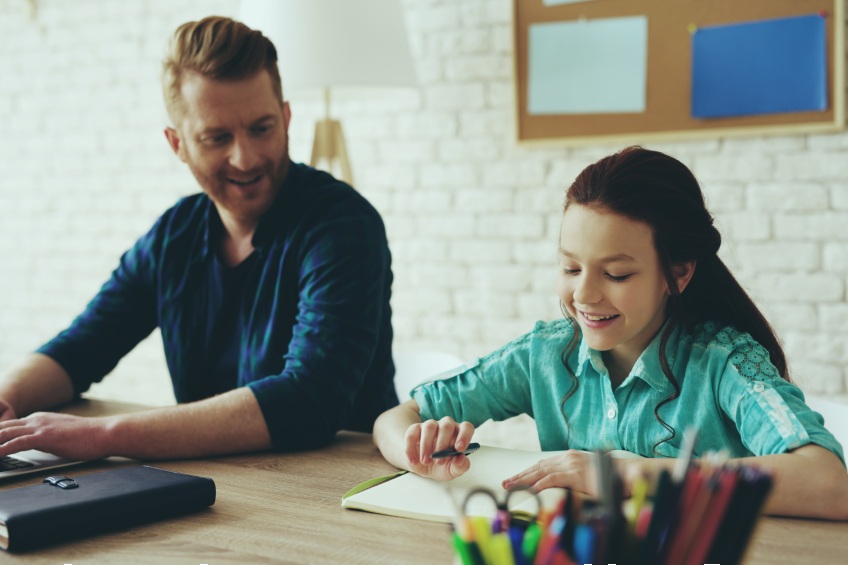 father and daughter working together at table