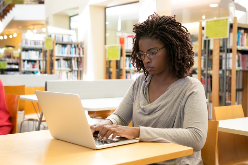 college student on computer in library